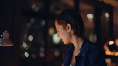 Akşam ofisinde çalışan başarılı yatırımcı gazeteleri yakından inceliyor. Finans raporunu okuyan gülümseyen iş kadını kârı tatmin etti. Hevesli kadın yönetici gece çalışma alanında evrak işleriyle uğraşıyor..