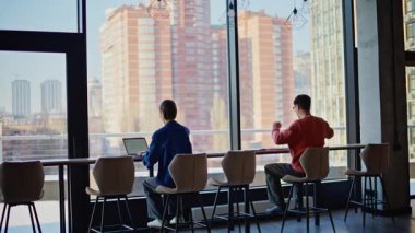 Kafe panoramik penceresinde proje geliştiren iki uzak işçi. Serbest çalışan bir adam açık alanda internetten iş bitiriyor. Geçmişe bakış meslektaşları uzaktan konuşuyor..