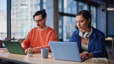 Arkadaş canlısı ekip modern ofisin açık alandaki görevini tartışıyor. Dizüstü bilgisayarlarla iş birliği yapan gülümseyen kadın. Bıyıklı yönetici kahve içiyor. İş yerinde çalışan bir kadınla konuşuyor.