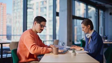 İki serbest çalışan, yakın çekim alanında konuşuyorlar. Kahve fincanı alan gülümseyen bıyıklı adam ofisteki dost canlısı bayan meslektaşla konuşuyor. İş yerinde işe ara veren yaratıcı takım arkadaşları.