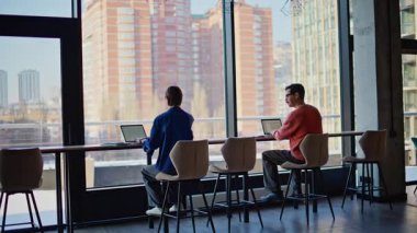 Modern bir açık alan arka görüşünde profesyonel girişimciler projesini planlıyorlar. İki iş adamı ofiste iş birliği hakkında konuşuyor. İş yerinde pazarlama stratejisi üzerinde çalışan meslektaşlar