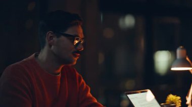 Aşırı yüklenmiş takım arkadaşları karanlık çalışma alanlarında son teslim tarihini tartışıyorlar. İki yorgun şirket çalışanı, gece ofisinde dizüstü bilgisayarlara bakarak konuşuyor. Sıkıntılı iş meselelerini fazla mesai yaparak çözen sinirli meslektaşlar.