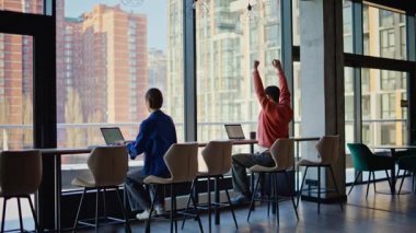 İki programcı iş yerinde bilişim projesini konuşuyor. Ofiste iş birliği yapan dost canlısı iş arkadaşları dizüstü bilgisayar arıyor. Profesyonel çalışanlar pencere açılışı için danışmanlık yapıyor