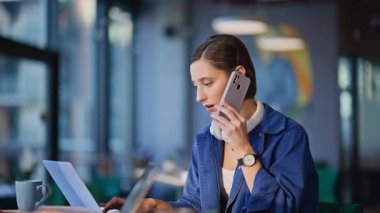 Şirket temsilcileri modern ofis iş yerindeki telefonları yakın çekimde konuşuyorlar. Gülümseyen kadın yöneticiler müşterilere cep telefonuyla yardım ediyor. Profesyonel çalışanlar akıllı telefondan müşterilerine danışıyor..