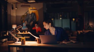 Dizüstü bilgisayar işyerinde gazete okuyan aşırı yüklenmiş girişimci. Yorgun iş kadını, gece ofisindeki yorucu iş yükünden dolayı bilgisayarını kapatıyor. Geç saatlere kadar çalışan kadın müdür kendini verimsiz hissediyor..