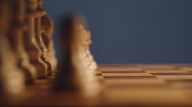 Kapalı alanda oynanan satranç maçında rakipler piyon taşıyor. Bilinmeyen oyuncular tahta tahtaya odaklanmış. İki rakip sırayla rakamları yükseltiyor. Stratejik düşünce ve entellektüel hobi