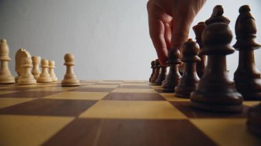 Satranç tahtasına ilk hamleyi kahverengi satranç eşyasıyla yapmak. Tanımlanamayan oyuncu oyuna davet ediliyor stratejik olarak piyonu hareket ettiriyor. Kimliği belirsiz kişi yalnız eğleniyor. Hobi ve eğlence konsepti 