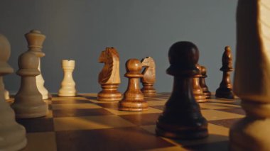 Savaş meydanında maun figürlerle dolu soluk piyonu kaldıran parmaklar. Sahne, yüksek gerilim koşulları altında hızlı bir muhakeme gücü ve berraklığı hesaplamayı ifade eder.