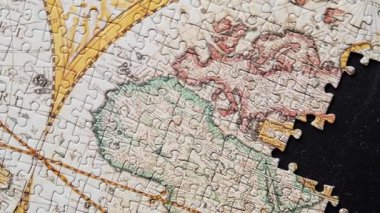 Bitmemiş küresel bulmaca, siyah yüzey üzerinde dinleniyor. Kısmi dizilimi yakından gösteriyor. Antik stil harita eksik, zorluk tamamlama bölümü. Çözümlenmemiş nesnel metafor kavramı