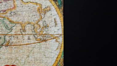 Hareket eden çekim, antik dünya haritasıyla tamamlanmış bir yapboz. Afrika Avrupa ve Asya da dahil olmak üzere kıtaların detaylı görüntüsü görünür. Bulmaca parçaları birbirine sıkıca uyuyor. Tarihsel Keşif