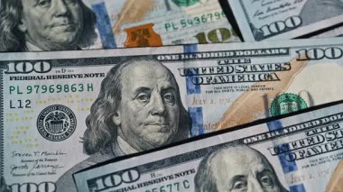 Benjamin Franklin 'in 100 dolarlık banknotta altın ışıklarla çekilmiş yakın plan görüntüsü. Yüzeyde yatan portresi Amerikan Başkanı 'na ait 100 adet yeni tip. Yığınla para nakit para banknotları