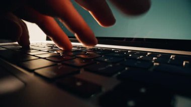 Ofiste dizüstü bilgisayarın klavyesini yazan bir adam var. İşadamı parmaklarını iş yerinde dijital cihazda çalıştırıyor. Aydınlatma dolabında dokunmatik dokunmatik defter kullanan tanınmayan bir adam. 