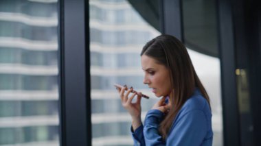 Ofis çalışanı pencerenin önünde hoparlörden konuşuyor. Profesyonel yönetici cep telefonunda ses tanıma sanal asistanı kullanıyor. Akıllı telefon sesli mesajı kaydeden kadın.