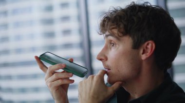 Kapanış adamı cep telefonuyla sesli mesaj kaydediyor. Modern ofiste cep telefonu hoparlörüyle konuşan ciddi bir iş adamı. Kapalı alanda sesli mesaj bırakan yakışıklı bir girişimci..