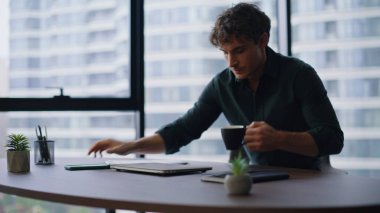 Genç işadamı işe koyulmaya başlar. Ofis masasına oturur, kahve fincanını kapatır. Ciddi yönetici verimli bir iş akışı için dizüstü bilgisayar açıyor. Sabahları kafein içen profesyonel bir çalışan.