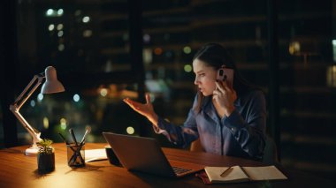 Aşırı yüklenmiş yönetici cep telefonuyla konuşuyor. Karanlık ofis masasında evrakları kontrol ediyor. Çalışkan iş kadını, bilgisayarlı iş yerini arayarak evrak hatasını tartışıyor. Ciddi yönetici fazla mesai yapıyor.