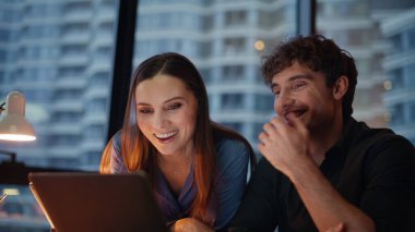 İş arkadaşları sanal toplantıda konuşuyor. Karanlık ofisteki web kameralarına bakıyorlar. Gülümseyen meslektaşlar akşam işyerinden arıyorlar. İki ortak internet sohbetinde dostça sohbetin keyfini çıkarıyor.