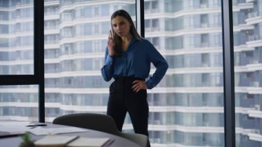Lüks bir şirkette kendine güvenen bir kadın telefon numarası çeviriyor. Ciddi bir iş kadını iş yerinde bekleyen ortakları arıyor. Panoramik pencerenin önünde duran zarif esmer kadın şehir manzaralı..
