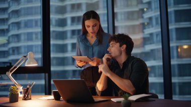 Akşam ofisindeki web kamerası laptopuyla konuşan yöneticileri arıyorum. İki iş arkadaşı karanlık uzayda online toplantıda iş projesini tartışıyor. Gülümseyen ortakların sanal konferansı vardır..