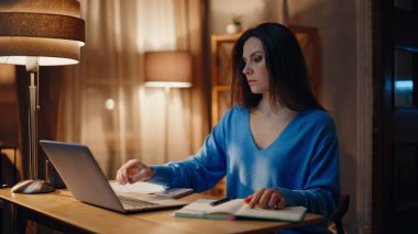 Çevrimiçi öğrenci laptopta geç dönem eğitim materyali okuyor. Uzaktan çalışmaya ara vermek için kahve fincanı alan ciddi bir serbest kadın. Sakin iş kadını planlama projesi gece evde