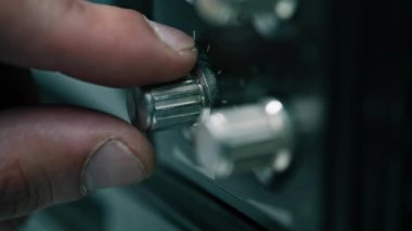 Makro görünüm parmakları eski radyo oynatıcılarının düğmelerine dokunuyor. Ses seviyesini düzenleyen tanınamaz bir adam içeride ses dengesini kontrol ediyor. Antika nostalji ve analog teknoloji. Müzik konseptinin belleği