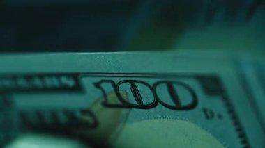 Kapalı mekanda elektronik kasanın kapandığını hesaplayan dolar faturaları. Otomatik ekipmanlar Amerikan kağıt banknotlarını da sayıyor. 100 'lük banknotlar. Banka işlemleri için işlem para nakit para 