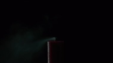 Karanlığın içinde mum alevini söndüren esinti. Balmumu ateşi siyah zeminde söner. Gece uzayı titreyen ışıkla hafifçe parlıyor. Sakin yansıtıcı ruh hali. Duman fitilden tepeye yükseliyor