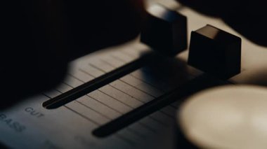 Retro müzikal ekipmanlarda parmaklar ses dengesini sağlıyor. Tanımlanamayan profesyonel ses mühendisi dijital mikserin ses kayıtlarını ayarlıyor. Bağbozumu konsolunun el çabukluğu.