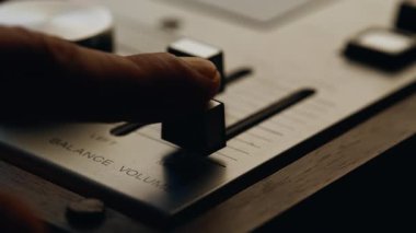 Klasik dijital ses karıştırıcının el dengeleme sesi. Bilinmeyen profesyonel, kapalı alanda retro müzik cihazını çalıştırıyor. Adam stüdyoda ses kaydı için ekipman ayarlıyor. Eski tarz.