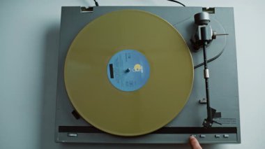 Adam klasik gramofona sarı disk takarak plağa başladı. Tanımlanamayan melomanyaklar klasik alet ayarlama iğnesini çalıştırıyor. Analog müzisyeni kapalı alanda retro kaydı döndürüyor