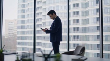 Başarılı bir iş adamı cep telefonunda duygusal evet hareketi gösteren neşeli bir mesaj veriyor. Çok mutlu bir yönetici akıllı telefon okuyor. Harika bir haber. Şaşırtıcı yönetici telefon aramasından zevk alıyor..