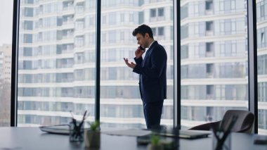 Başarılı yatırımcı, ofisin panoramik penceresinde anlaşma detaylarını tartışırken cep telefonuyla konuşuyor. Şık CEO, şehir manzarasına bakan ortakları arıyor. Kendine güvenen iş adamı iş telefonuyla konuşuyor..