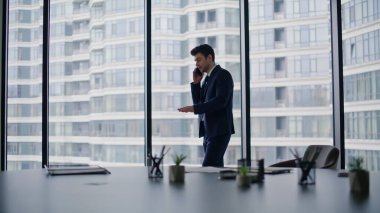 Ofis panoramik penceresinde akıllı telefonla pazarlık yapan zarif bir yönetici. Başarılı bir iş adamı şirket işyerindeki cep telefonunu arıyor. Güvenilir yöneticiler iş görüşmelerini cep telefonuyla yaparlar.