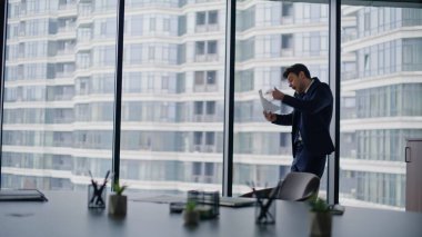 Öfkeli CEO 'nun cep telefonunu araması ofis penceresinden dökümanları fırlatması. Sinirli iş adamı cep telefonundan şikayetçi. Kızgın işletme yöneticisi stresli sohbeti bitiriyor