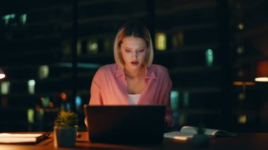 İş kadını, karanlık şirket ofisindeki belgeleri inceliyor. Aşırı yüklü kadın muhasebeci şirket sonuçlarından memnun olmayan mali raporları inceliyor. Yorgun bayan serbest çalışan akşam geç saatlere kadar çalışan.