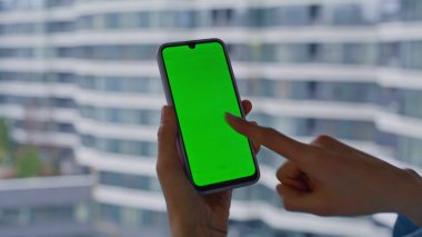 Serbest çalışan parmak krom tuşlu akıllı telefona dokunuyor. Pencereyi kapatarak online uygulamayı açıyor. Yeşil ekranlı cep telefonuyla internet alışverişi yapan tanınmayan bir kadın. Model cep telefonuyla mesaj gönderen bayan.