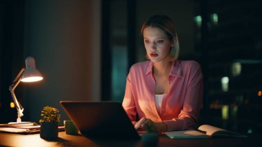 Karanlık Daire 'de geliştirme projesi geliştiriyor. Ciddi bir iş kadını, gece ofisindeki not defterinde dizüstü bilgisayarını inceliyor. Profesyonel uzaktan işçi planlama başlangıç fazla mesaisi.