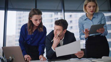 Grup başlatıcıları şirket ofisindeki dizüstü bilgisayardaki verileri kontrol ediyorlar. Hevesli üç meslektaşım mali belgeleri inceliyor. İş ortakları iş projesini tartışıyor.