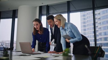 Heyecanlı personel, şirket çalışma sahasında dizüstü bilgisayar arayışında başarıya seviniyor. Mutlu ofis ekibi iş zaferini kutlamak için kağıtları fırlatıyor. Üç meslektaşımın zafere duygusal tepki göstermesi beni çok mutlu etti.