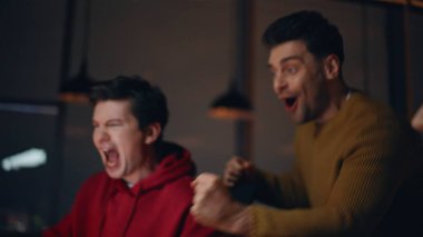 Coşkulu iş adamları gece ofislerinde duygusal olarak başarıyı kutluyorlar. Gülümseyen takım başlangıç zaferinin tadını çıkarıyor. Heyecanlı grup arkadaşları gecenin geç saatlerinde başarı kutlamaları yapıyorlar..