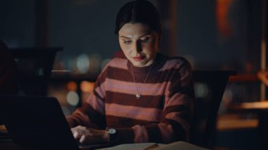 Girişimciler karanlık ofis alanında proje oluşturuyorlar. İki meslektaş gece geç saatlerde dizüstü bilgisayarlar üzerinde çalışıp defterlerine notlar yazıyorlar. Uzaktan çalışmaya odaklanmış bilgisayar arayan profesyonel çevrimiçi yöneticiler