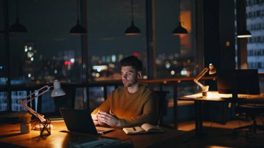 Elinde kahve fincanı tutmaktan yorgun düşmüş bir programcı. Gece vardiyasında sıcak içecek içen, dizüstü bilgisayarı olan bir gece çalışanı. Ciddi bir profesyonel, fazla mesaiye ara veriyor..