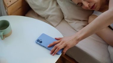 Alarmlı akıllı telefon arayan yorgun bir kadın evde yatıp, kamerayı kapatıyor. Üzgün esmer, cep telefonuyla hafif yatak odasındaki yumuşak battaniyeyi örtüyor. Uykusuz genç bayan sabahın erken saatlerinde apartmanda uyanıyor..