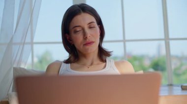 Düşünceli bayan, dizüstü bilgisayarını kapatıyor. Yatak odasını pencereye yakın tutuyor. Ciddi serbest çalışan, internetteki işini bitiren, beyaz yatakta dinlenen bir bilgisayar. Güzel kadın yazar sabahları ilham arıyor..