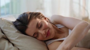 Uykucu esmer, akıllı telefonlu. Romantik bir mesaj alıyor. Yatakta rahat bir şekilde yatıyor. Sabahın köründe cep telefonu okuyan gülümseyen kadın. Telefonu elinde tutan mutlu bayan kendini aydınlık yatak odasında hissediyor..