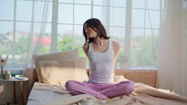 Uyanık kadın, yumuşak bir yatakta bacak bacak üstüne atarak uzanıyor. Rahat ev yatağında sabah erkenden kaslarını ısıtan rahat bir kadın. Gülümseyen esmer, sağlıkla ilgilenen, yatak odasında egzersiz yapan..