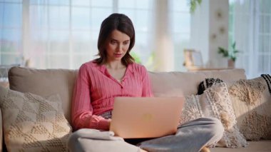 Uzaktan kumandalı bir öğrenci rahat bir oturma odasında dizüstü bilgisayarını bağdaş kurarak kapatıyor. Gülümseyen kadın serbest çalışan tatmin olmuş evde internet işini bitiriyor. Mutlu bayan bilgisayar alışverişini seviyor..