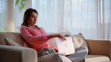 Uzaktan kumandalı işçi rahat bir kanepede oturuyor. Genç bir kadın sabah oturma odasında bilgisayarın klavyesine yazmaya başlıyor. Gülümseyen esmer serbest yazar. Ev koltuğuna iş e-postası yazıyor..