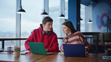 Uzaktan kumandalı işçiler ofiste iş arayan dizüstü bilgisayarları yakın plan çekimde tartışıyor. Dost canlısı kadın serbest çalışanlar iş yerinde gülümsüyor. Proje üzerinde birlikte çalışan yaratıcı girişimciler.