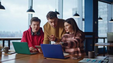 Modern işyerindeki şirket CEO danışman meslektaşları yakın plan. Ofis ekibi birlikte dizüstü bilgisayar arayarak online proje üzerinde beyin fırtınası yapıyor. Arkadaş canlısı akıl hocası genç iş arkadaşlarına yaratıcı fikirlerinde yardım ediyor..